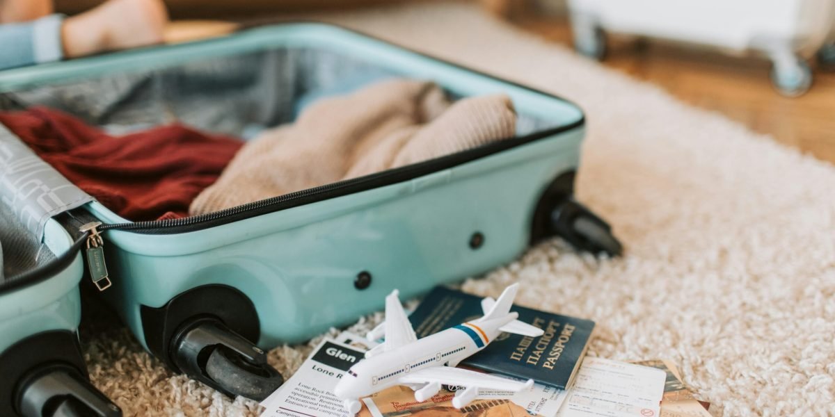 Close-up of an open suitcase with travel essentials like passport and tickets, ready for a journey.
